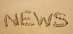Die Buchstaben NEWS im Sandstrand geschrieben