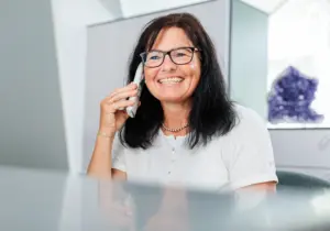 Lächelnde Dame am Telefon an der Rezeption