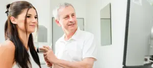 Dr. Werner bei der Hautkrebsvorsorge einer jungen Patientin